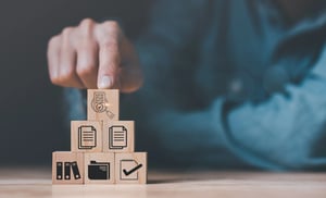 Menschenhände, Holzklötze und Symbole – Konzept der Qualitätsbewertung vor der Freigabe